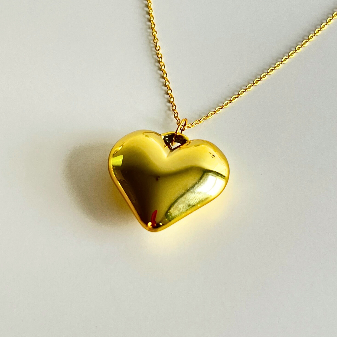 Close-up van goudkleurig hartje op lange ketting